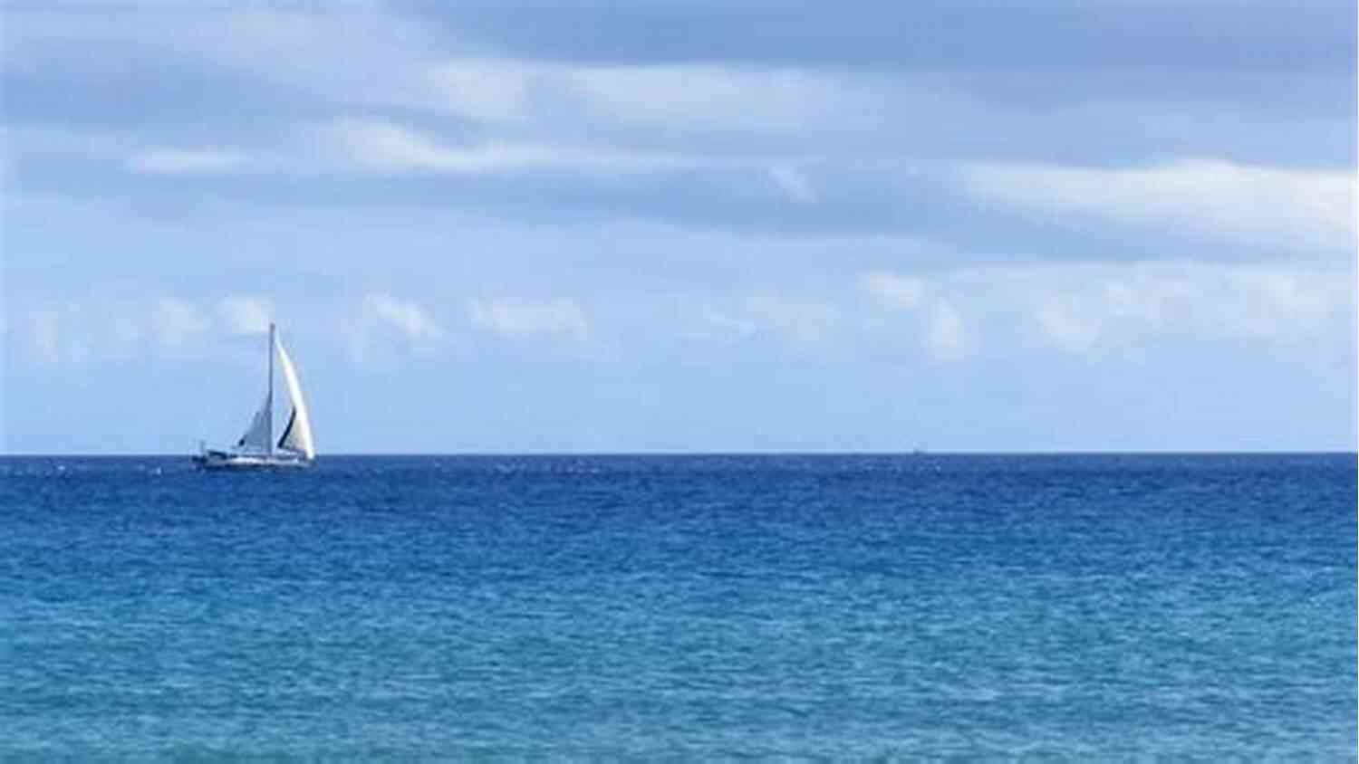 A Breathtaking View Of The Open Sea With A Sailboat In The Distance Unfortunate Breeze: A Bluewater Breeze Novel (Meade Breeze Adventure 25)